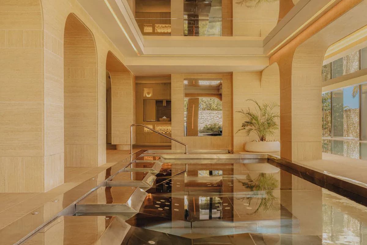 Hydrotherapy circuit at SHA Spain featuring a reflection pool, stone walls, and an archway, with a potted plant in the corner.
