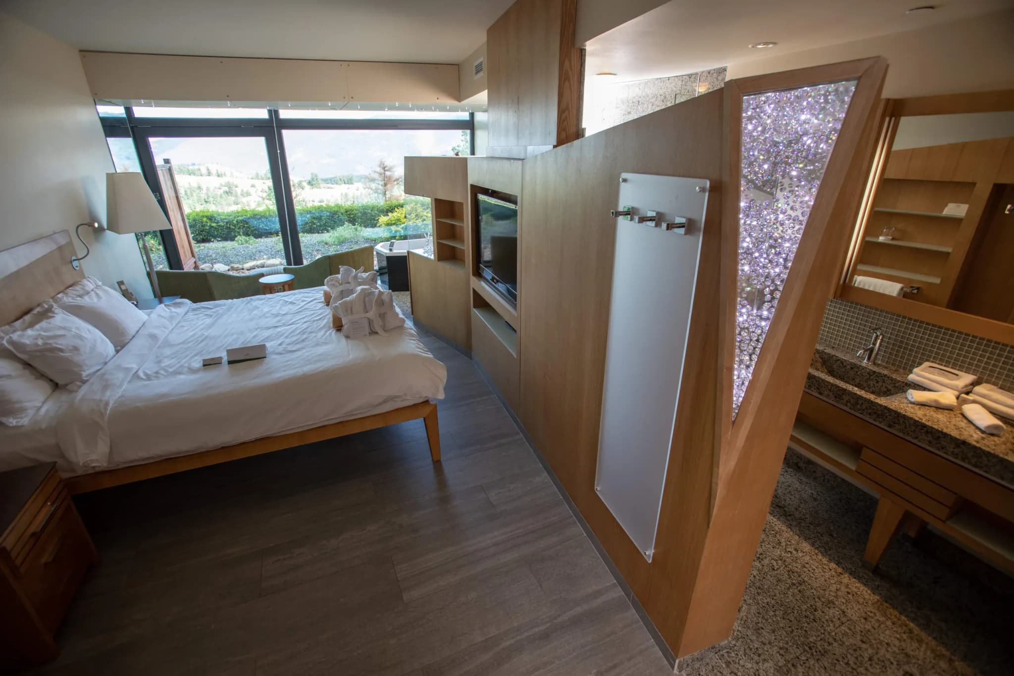 Bedroom at Sparkling Hill Resort featuring a bed, wooden furnishings, and a mirrored wall with Swarovski crystals.