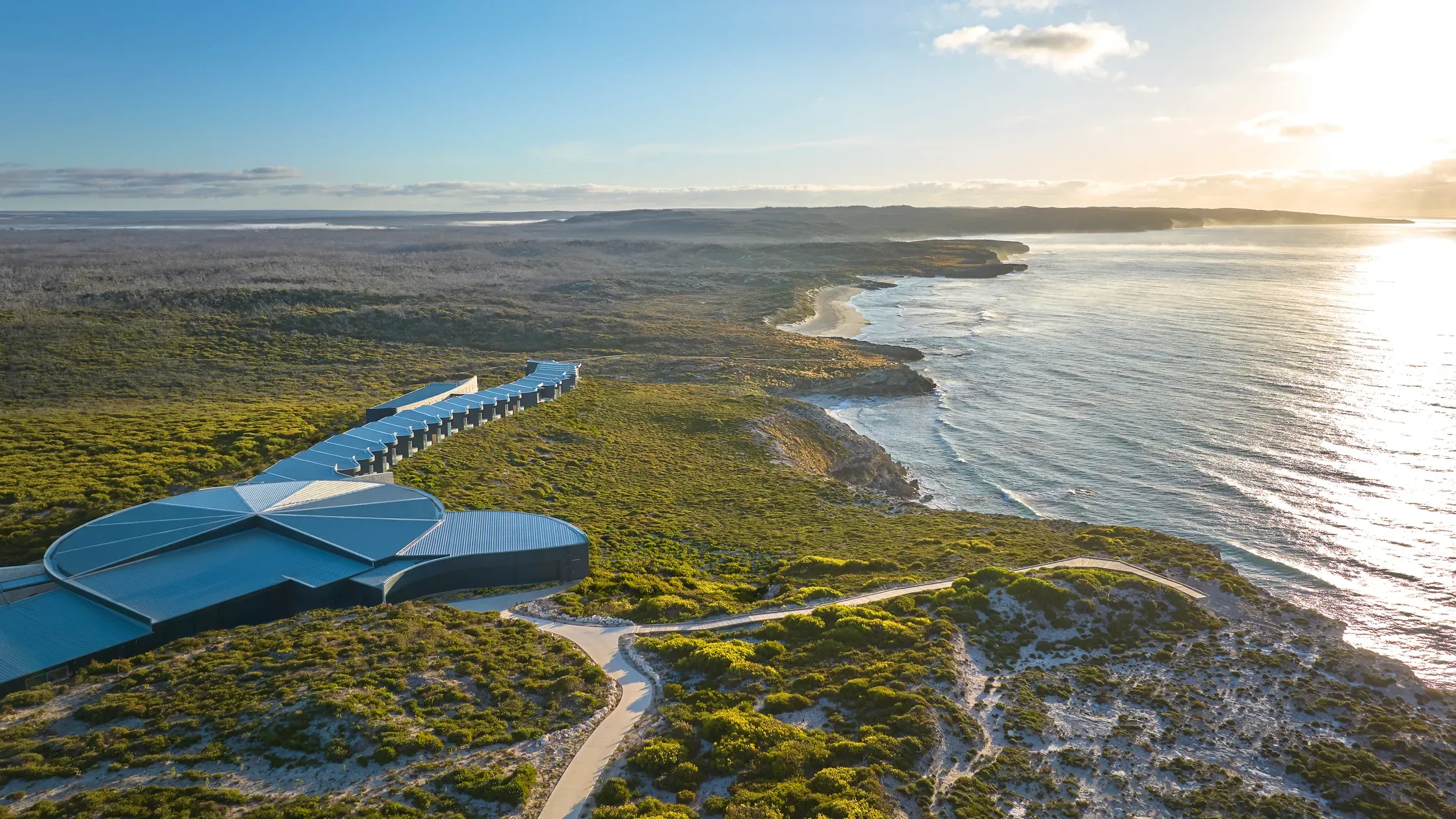 Aerial view of Southern Ocean Lodge, situated on a cliff edge overlooking the ocean and surrounding greenery.